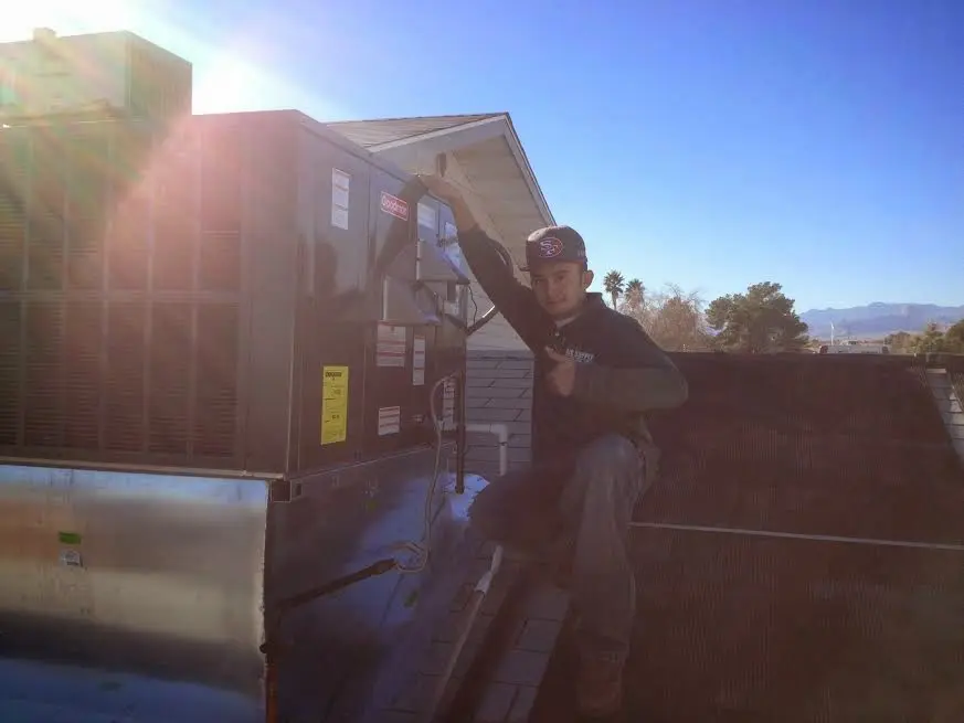 HVAC technician performing AC Tune-Up on a rooftop unit in East Marlborough